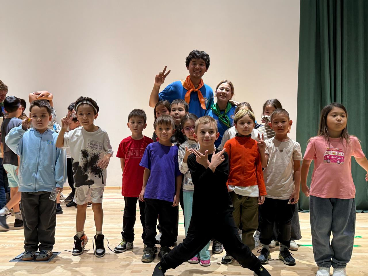 Дети весело позируют в актовом зале