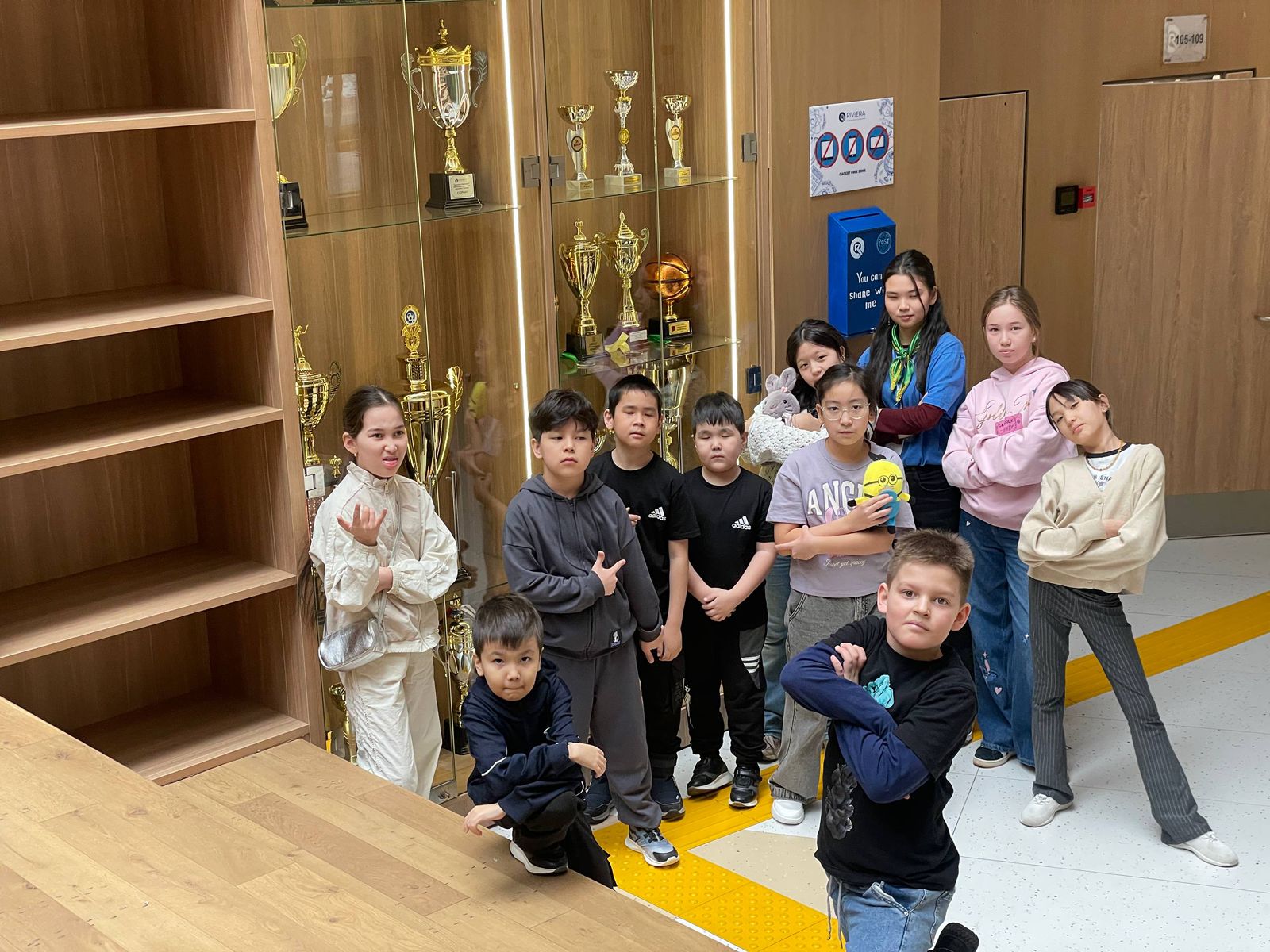 Группа детей и вожатых у витрины с кубками